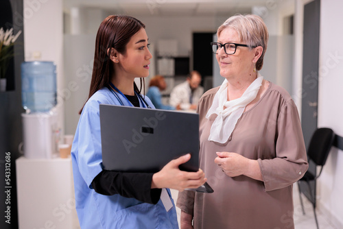 Valokuva Hospital pharmacist guiding elderly caucasian woman with medications, treatments