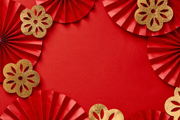 Chinese New Year festival decorations on red background. Red paper fans with golden decorations top view. Lunar New Year banner design.