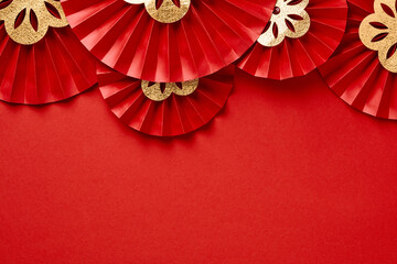 Chinese New Year 2023 year of the rabbit decorations on red background. Red paper fans with golden decorations. Lunar New Year banner template. Flat lay, top view.