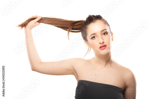 Beautiful girl close studio portrait against white background. Holding hair in the air.