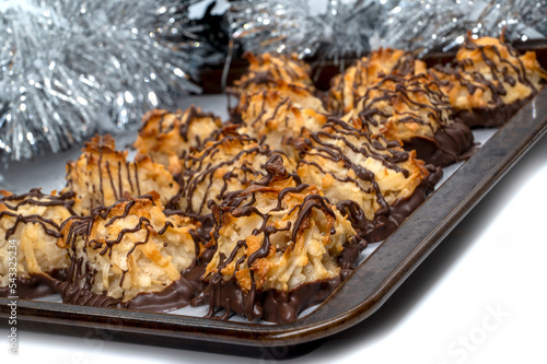 Homemade cookies with coconut on baking tray. Chocolate drizzled coconut macaroons , selective focus. Christmas cookies 