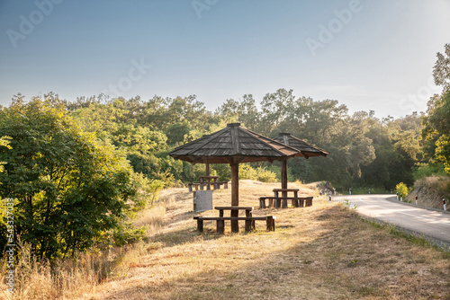 Wooden picnic table with an umbrella made of wood in fruska gora, in vojvodina, a national park of serbia, during a summer sunset used by people for leisure, relaxing, picnicking or having a brea © Jerome