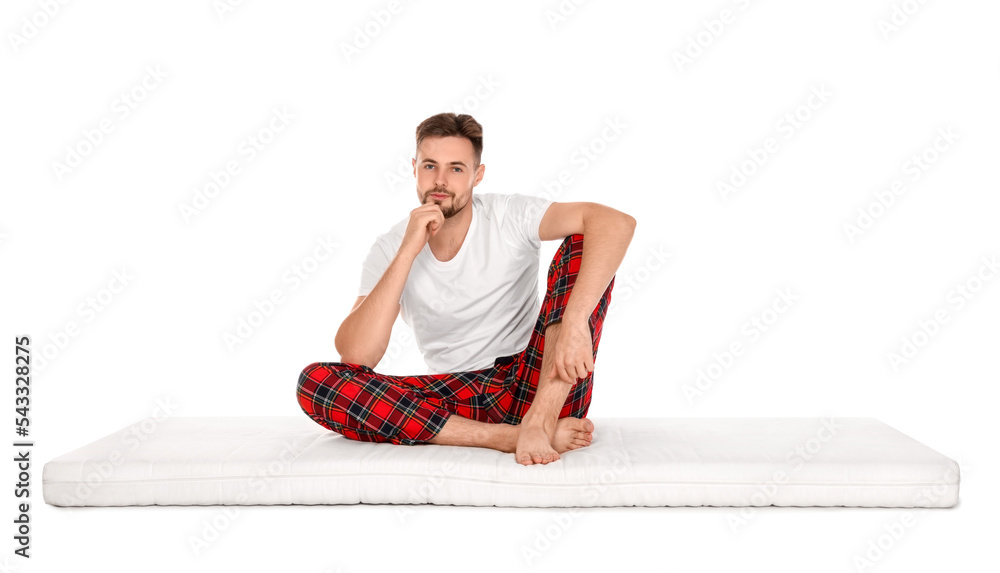 Fototapeta premium Man sitting on soft mattress against white background