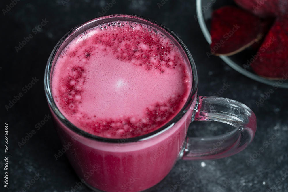 Beetroot vanilla latte from fresh beetroot juice blended with vanilla and milk in a transparent cup on the table in cafe, closeup. Trendy healthy drink Beetroot vanilla latte from fresh beetroot juice blended with vanilla and milk in a transparent cup on the table in cafe, closeup. Trendy healthy drink