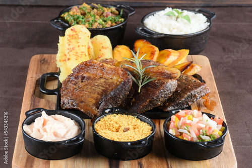 barbecued meat with cassava fried banana rice beans and herb sauce, typical brazilian food