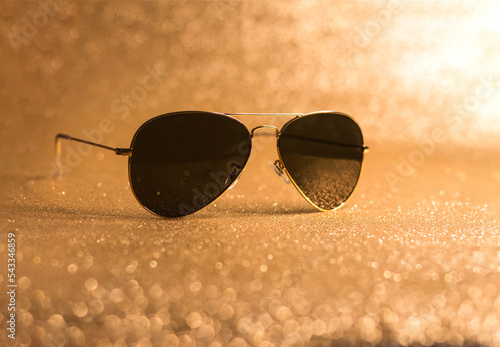 Luxury Aviator design sunglasses on golden background photo
