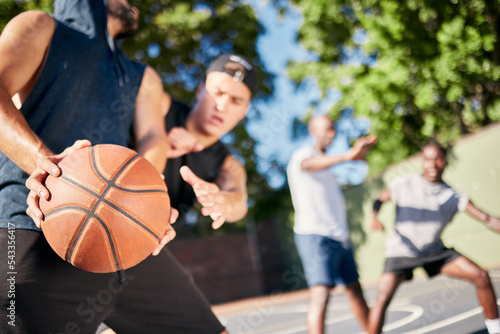 Fitness, sports and friends on a basketball court playing a game, training match and cardio workout exercise. Teamwork, diversity and healthy men enjoy a challenge with intensity in summer together