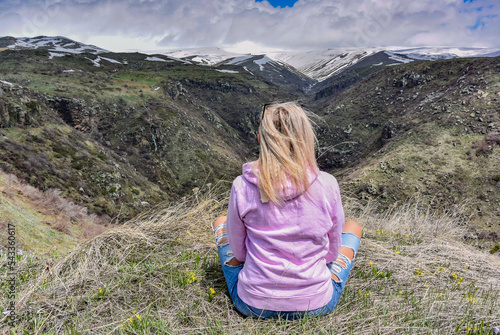 A girl on mount Aragats near the 7th-century Amberd fortress, at the confluence of the Arkashen and Amberd rivers, Armenia. photo