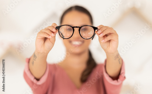 Vision, eyesight and woman with glasses in hands for eye test, holding spectacles in blurred background. Healthcare, medical insurance and eyes, girl in blur with prescription lens in spectacle frame
