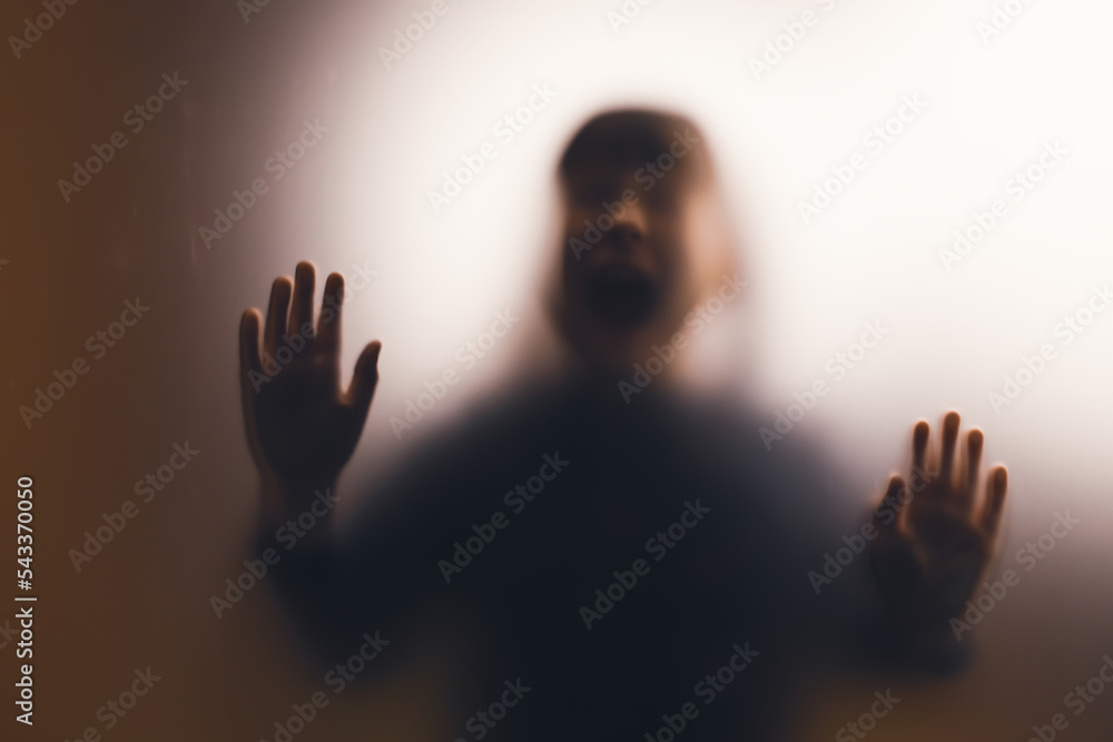 Shadowy figure, child behind glass - horror background Shadowy figure, child behind glass - horror background