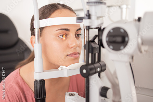 Vision, ophthalmology and woman in eye exam with light on iris at eye doctors office. Healthcare, medical insurance and eyes, girl getting healthy visual refraction eye test at ophthalmologist clinic