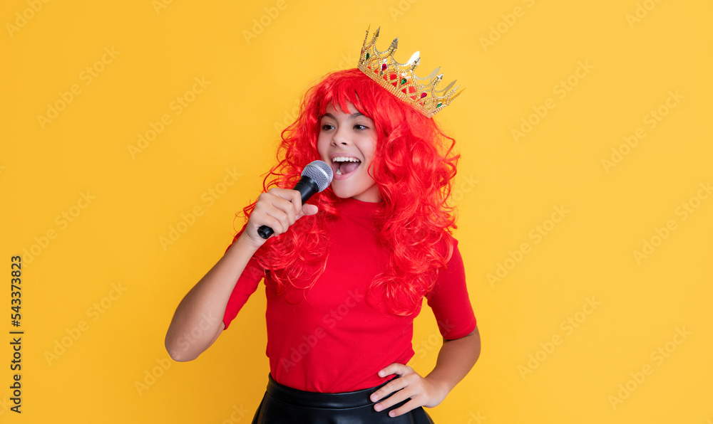 smiling kid in crown with microphone on yellow background smiling kid in crown with microphone on yellow background