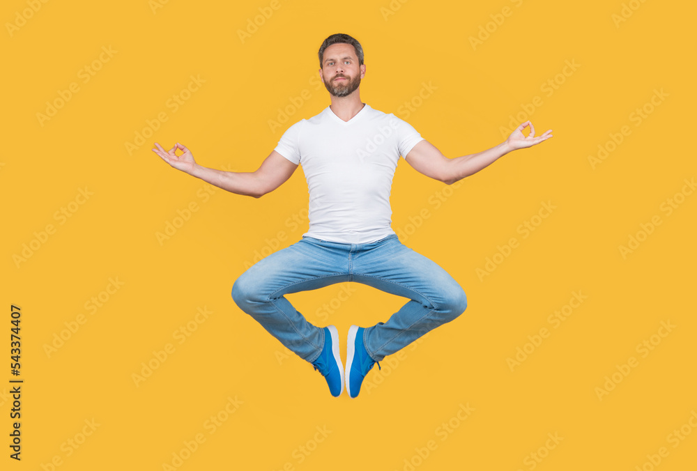 man having levitating meditation isolated on yellow background. meditation guy with mudra gesture.
