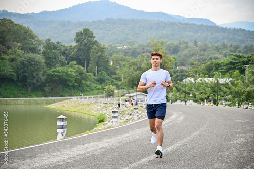 Healthy and active Asian man running or jogging at the beautiful lake. Healthy lifestyle © bongkarn