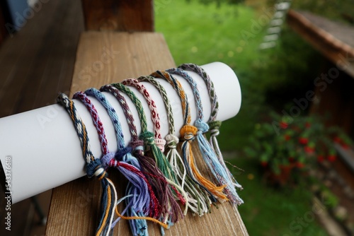 Multicolored handmade kumihimo bracelets on the background of the balcony overlooking the garten.