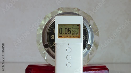 Radioactive clock with a radium isotope in the paint on the hands and dial. Measurement of radioactivity with a dosimeter radiometer