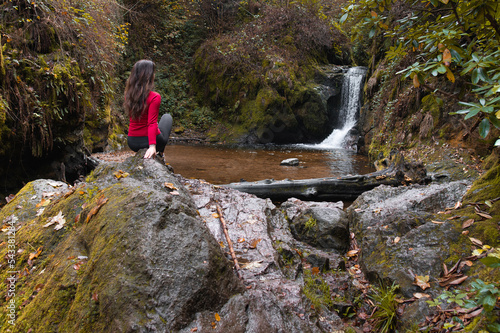 Frau schaut sich im Schwarzwald einen Wasserfall an