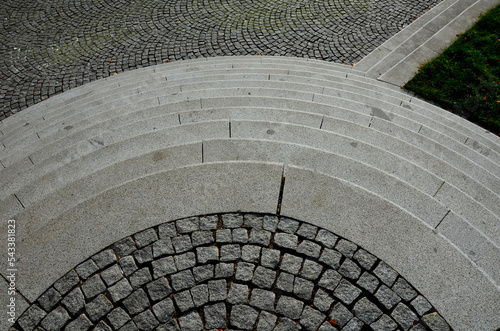 stairs to the waterfront. you enter through the gate via the circularly arranged cone-shaped stairs, breaking apart like the overflow of a clock, lawn, bench, seat, gray, granite, wall  urban, street photo