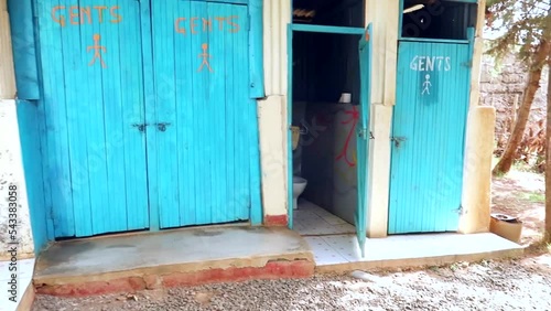 View of tourist bathroom with bright blue doors marked ladies and gents in an area of Kenya, Africa