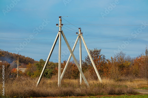 Electricity pylons in the countryside of Ukraine. Concrete poles and electric wires against the blue sky