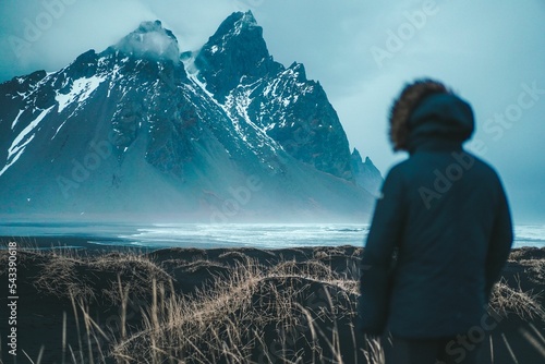 Back view of human standing in front of Vestrahorn mountain photo