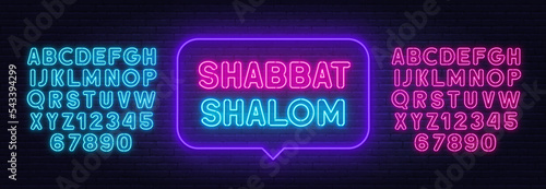 Shabbat Shalom neon sign in the speech bubble on brick wall background.