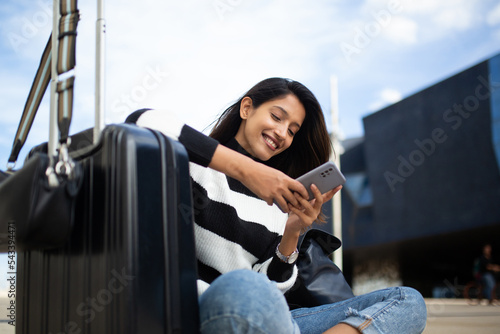 happy travel woman sitting with mobile phone