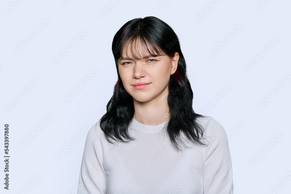 Young woman making grimace, showing trouble, on white background Young woman making grimace, showing trouble, on white background