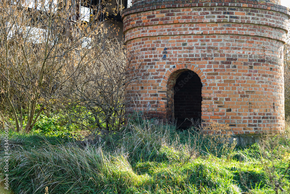arched entrance to an old brick chimney on an abandoned