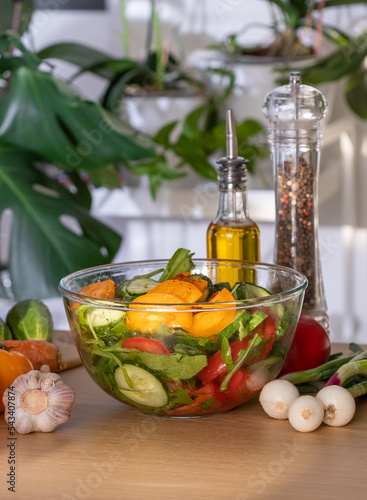 Fototapeta Naklejka Na Ścianę i Meble -  Salad. Vegetable Fresh Salad with Tomatoes, Cucumbers, Scallion and Olive Oil. Healthy Food. Vegetarian Diet. Making vegetable salad in the kitchen at home, Cutting Vegetables close-up
