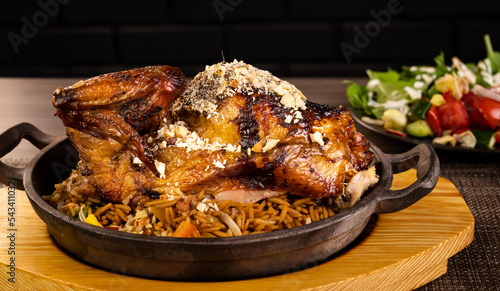 Whole roasted chicken with vegetables, on wooden table,