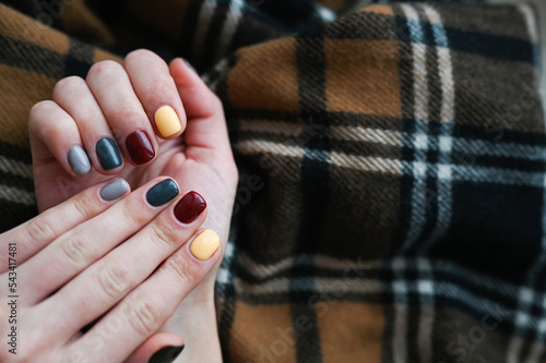 Luxury short manicure on a dark wooden background. cozy autumn nails. 
