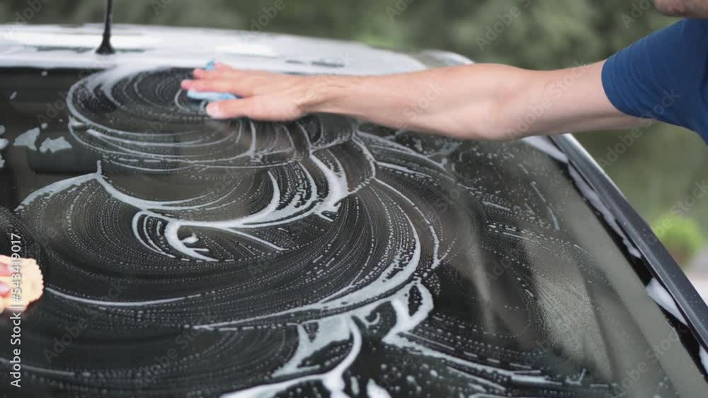 Selfservice car wash. Happy couple washing car and having fun on sunny