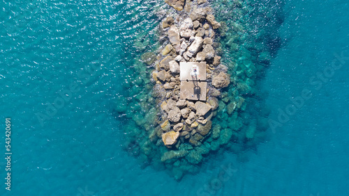 Lighthouse on top of wave breakers on a small harbor in Karlovasi, Greek island of Samos
