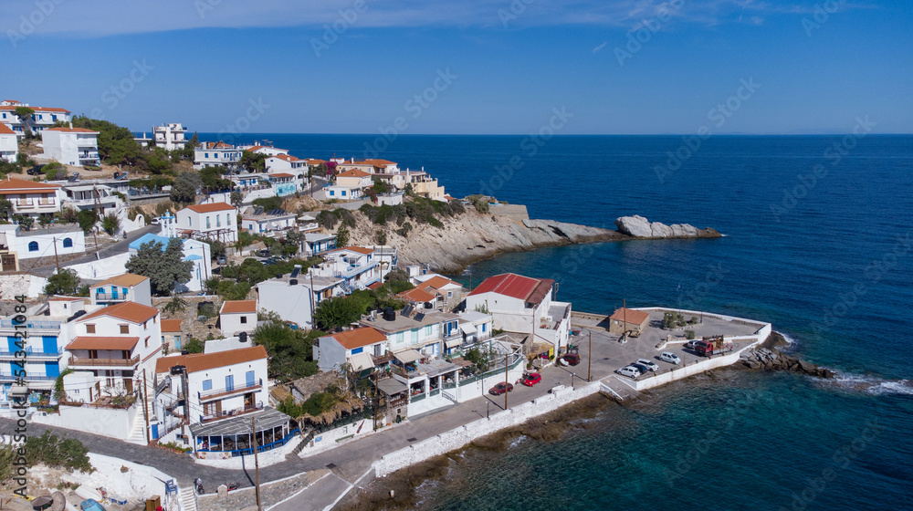 Obraz premium Aerial view of lovely greek fisher town of Armenistis in a quiet summer morning. Port with local beach in transparent clear water at Ikaria, Greece