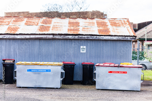 Large skip bins for rubbish and recycling behind business and shed photo
