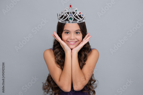 Girls party, funny kid in crown. Child queen wear diadem tiara. Cute little princess portrait. Happy girl face, positive and smiling emotions. © Olena