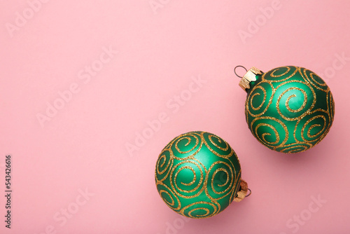 Green shiny christmas ball on pink background