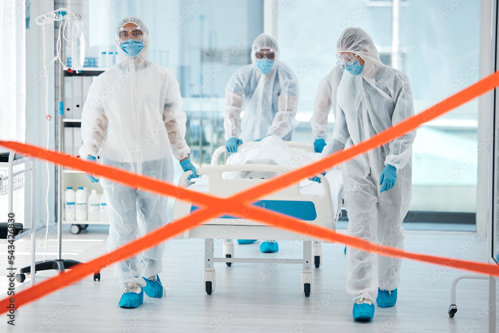 Naklejka premium Covid quarantine, medical team and patient in bed, moving to isolation or test area with warning tape in hospital. PPE suits, safety and healthcare, group of doctors or nurses move body on stretcher.