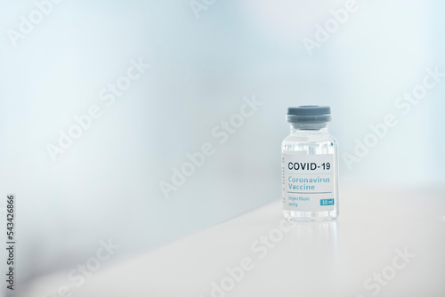 Covid, vaccine and medication with a bottle of a liquid on a table in the hospital as a cure or treatment. Healthcare, pharmacy and medicine in a corona research lab for pharmaceutical development