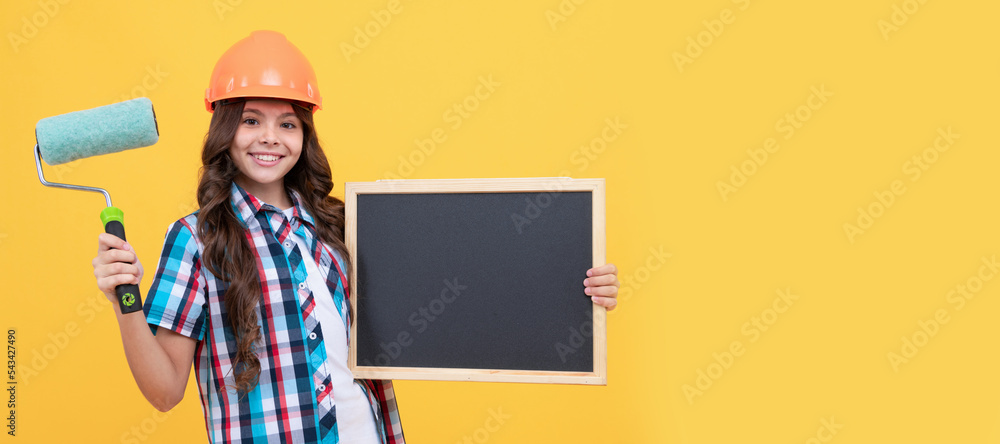Builder teenager girl in helmet. happy child with curly hair in helmet hold paint roller and school blackboard copy space, renovation. Child builder in helmet horizontal poster design. Builder teenager girl in helmet. happy child with curly hair in helmet hold paint roller and school blackboard copy space, renovation. Child builder in helmet horizontal poster design.