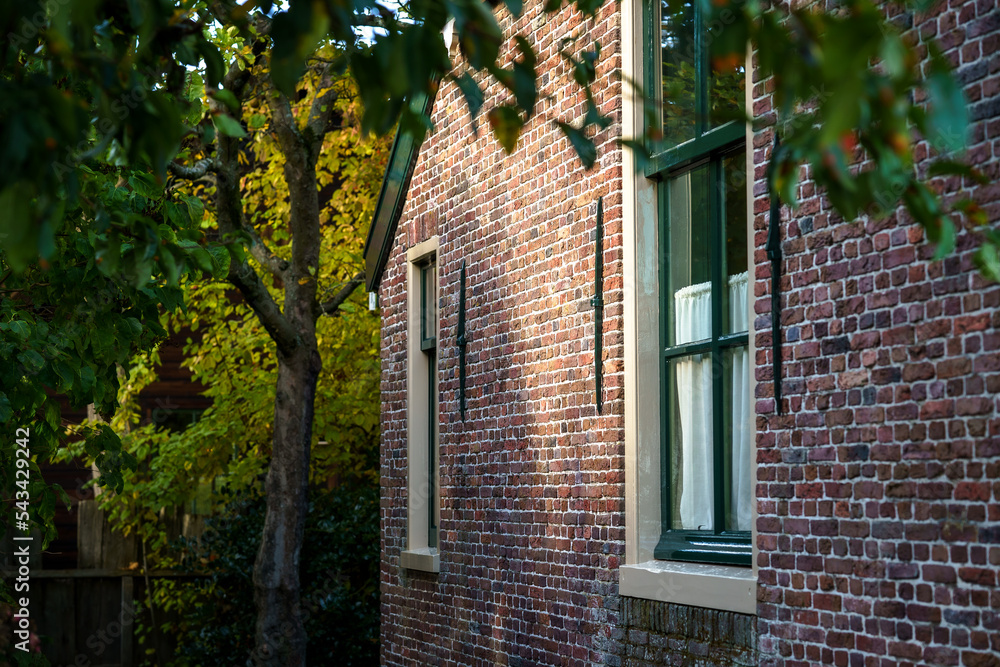 Fototapeta premium Side view of brick house with striking sunlight in authentic environment