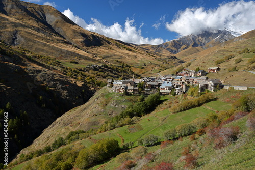 Le Chazelet village in Ecrins National Park, Romanche Valley, Hautes Alpes (French Southern Alps), France, with Autumn colors and Mas de la Grave Peak in the background photo