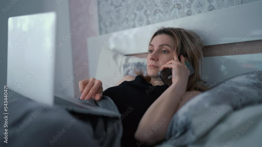 Lady lying on bed and surfing internet. Concept of travelling and technology. Female freelancer working at home or in a hotel room. Work remotely from the office. Woman working in bed using laptop Lady lying on bed and surfing internet. Concept of travelling and technology. Female freelancer working at home or in a hotel room. Work remotely from the office. Woman working in bed using laptop
