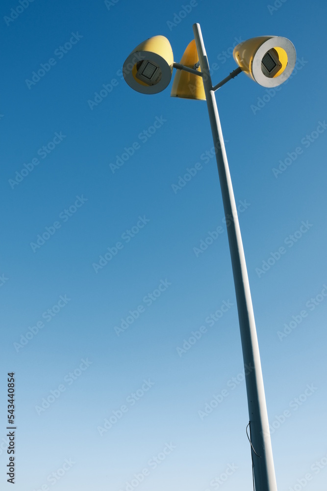 A street lamp standing against the blue sky. A street lamp standing against the blue sky.