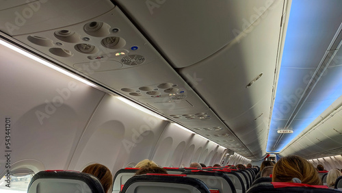 Sitzreihen im Flugzeug mit Fenstern und lichtblauer Beleuchtung