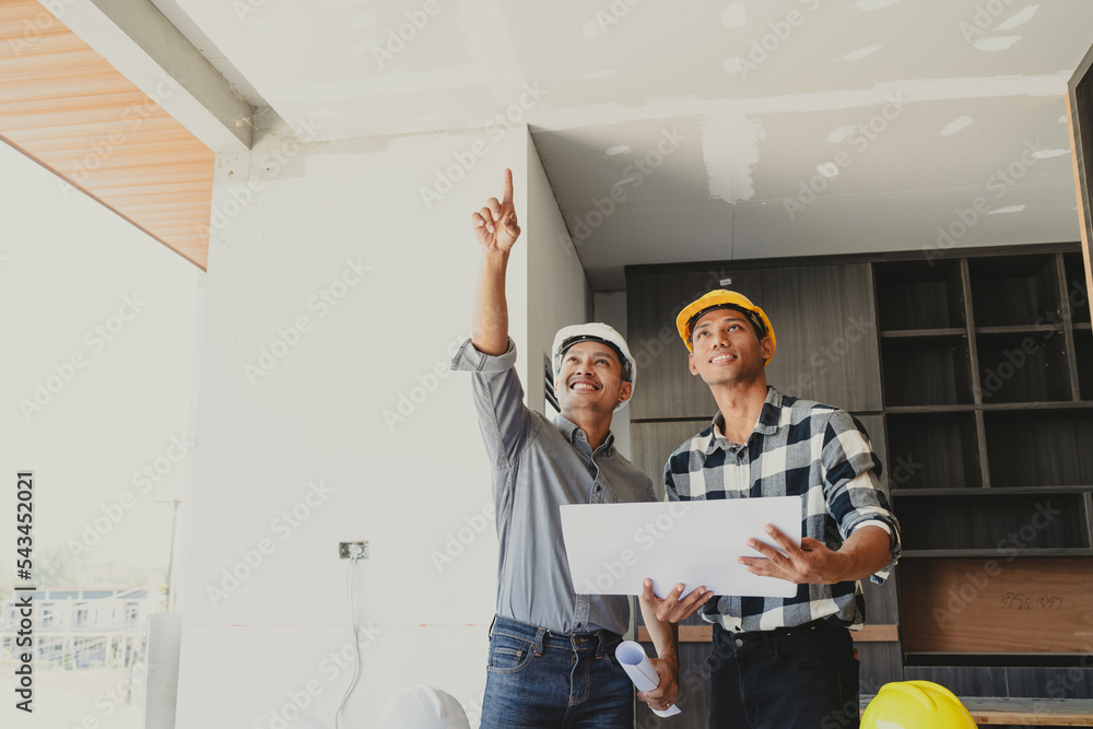 Successful home renovation describes and examines newly built and renovated construction holding large house blueprints. Successful home renovation describes and examines newly built and renovated construction holding large house blueprints.