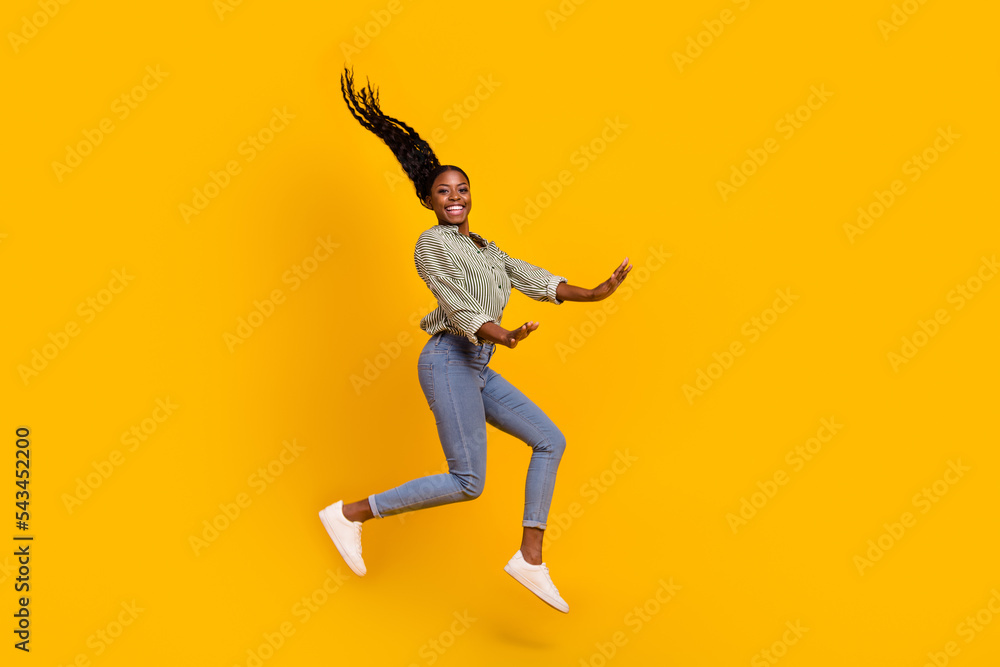 Full length portrait of pretty cheerful girl jump have fun rejoice isolated on yellow color background