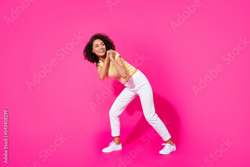 Full size photo of young adorable pretty woman pull abstract object look empty space interested information isolated on pink color background