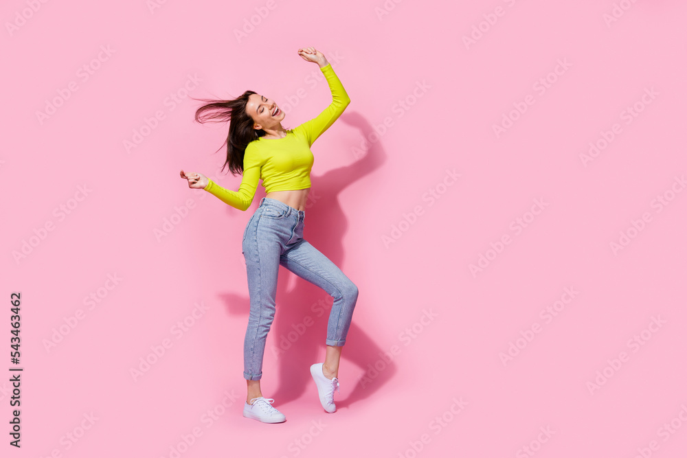 Full length photo of pretty cheerful crazy positive trendy girl enjoy clubbing empty space isolated on pink color background Full length photo of pretty cheerful crazy positive trendy girl enjoy clubbing empty space isolated on pink color background